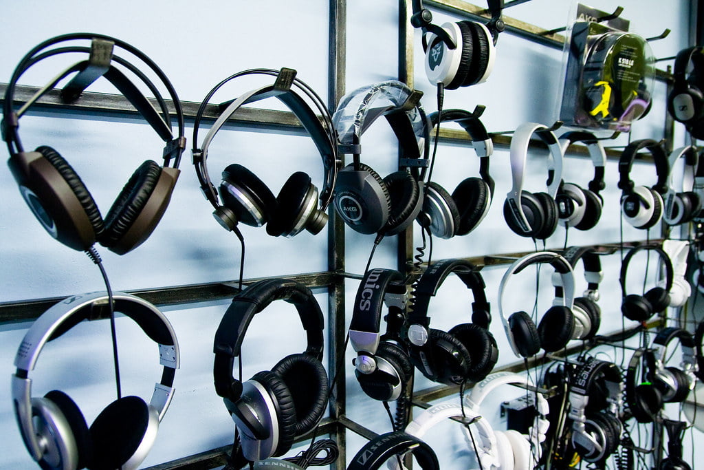 Assorted headphones displayed on a wall rack in a retail setting.