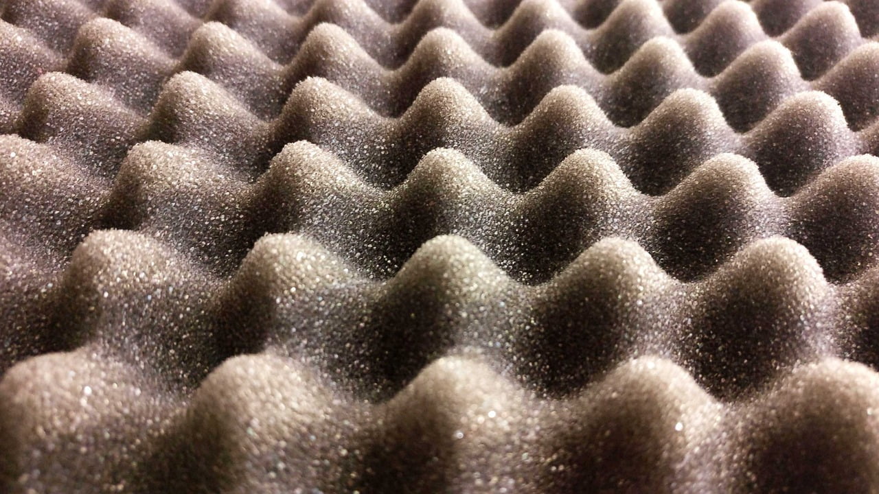 Close-up of a black acoustic foam panel with a convoluted egg crate pattern.