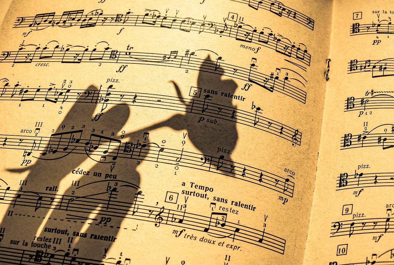 Sheet music with shadow of a person's hand forming a bird silhouette.