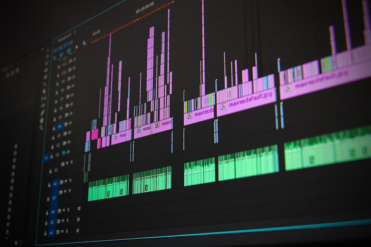 A close-up of a computer screen displaying a digital audio workstation with colorful audio waveforms and track labels.