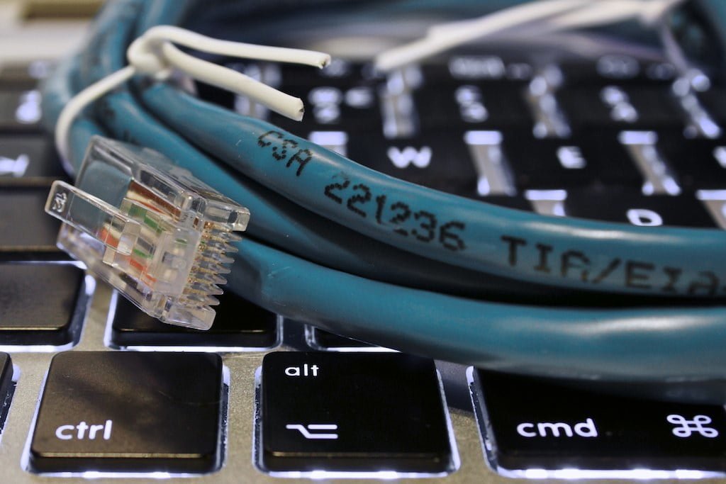 An Ethernet cable with an RJ45 connector lying on a laptop keyboard, highlighting the "ctrl" and "alt" keys with markings on the cable.