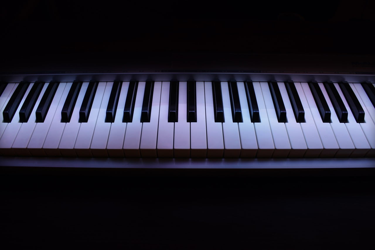 A close-up view of piano keys with a soft light highlighting the black and white keys.